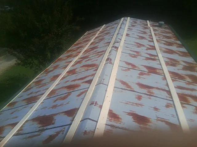 Rusted metal roof panels with new wood purlins before replacement — Storm Damage Roof Repair in Yutan by Roofing Brothers
