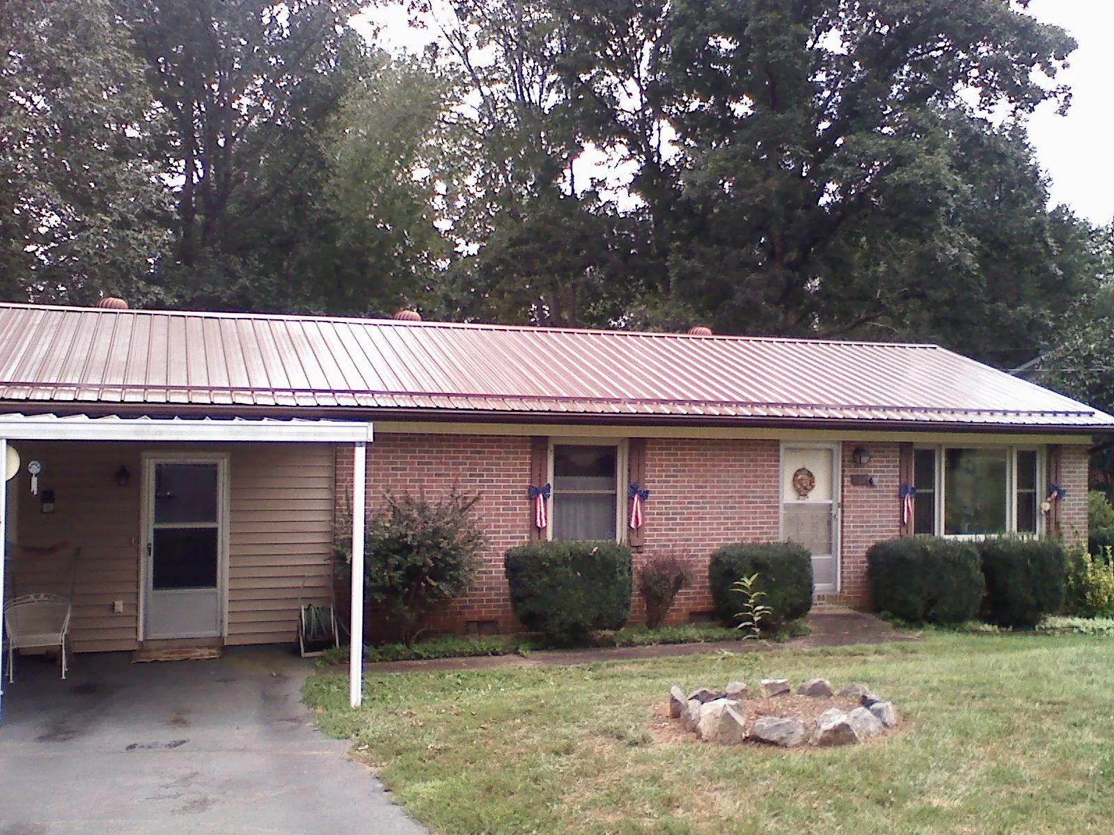 Bronze metal roof and carport on a brick ranch home — Roof Repair work by our crew in Yutan